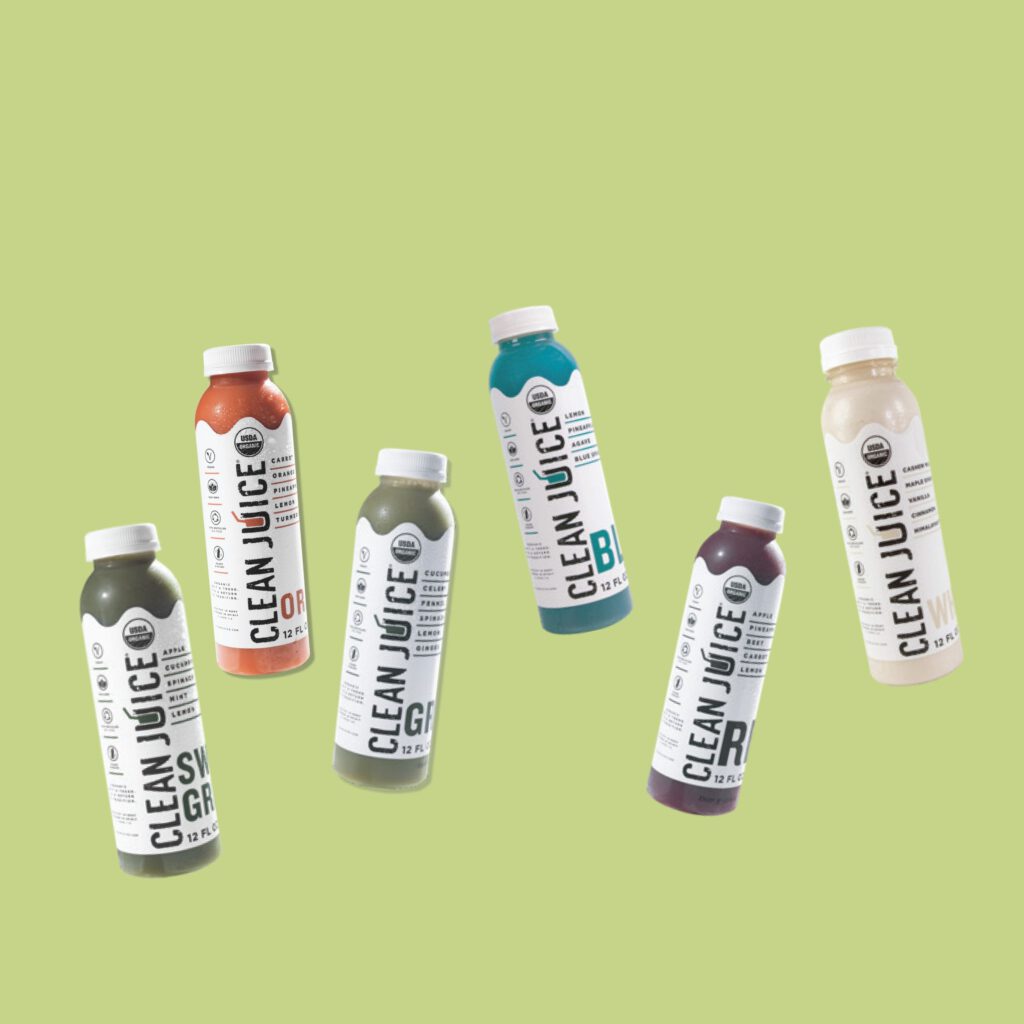 six floating bottles containing different clean juice cleanses